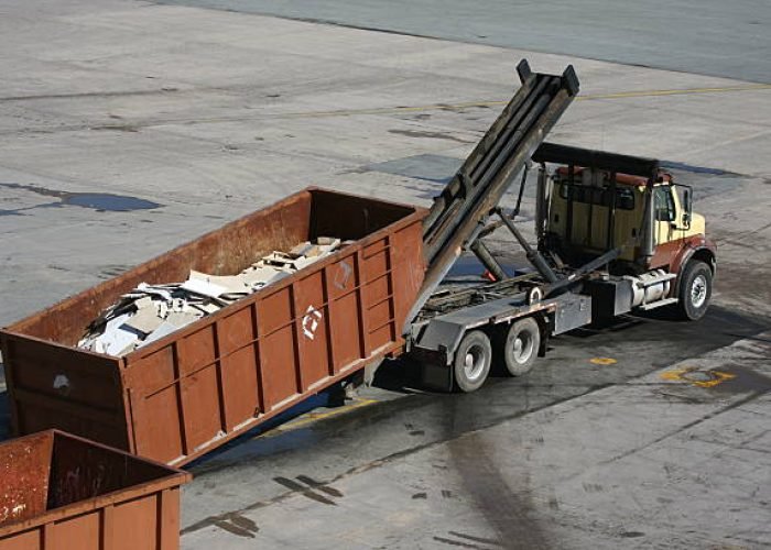 a large refuse bin is pulled up on a specially equipped waste removal truck.
